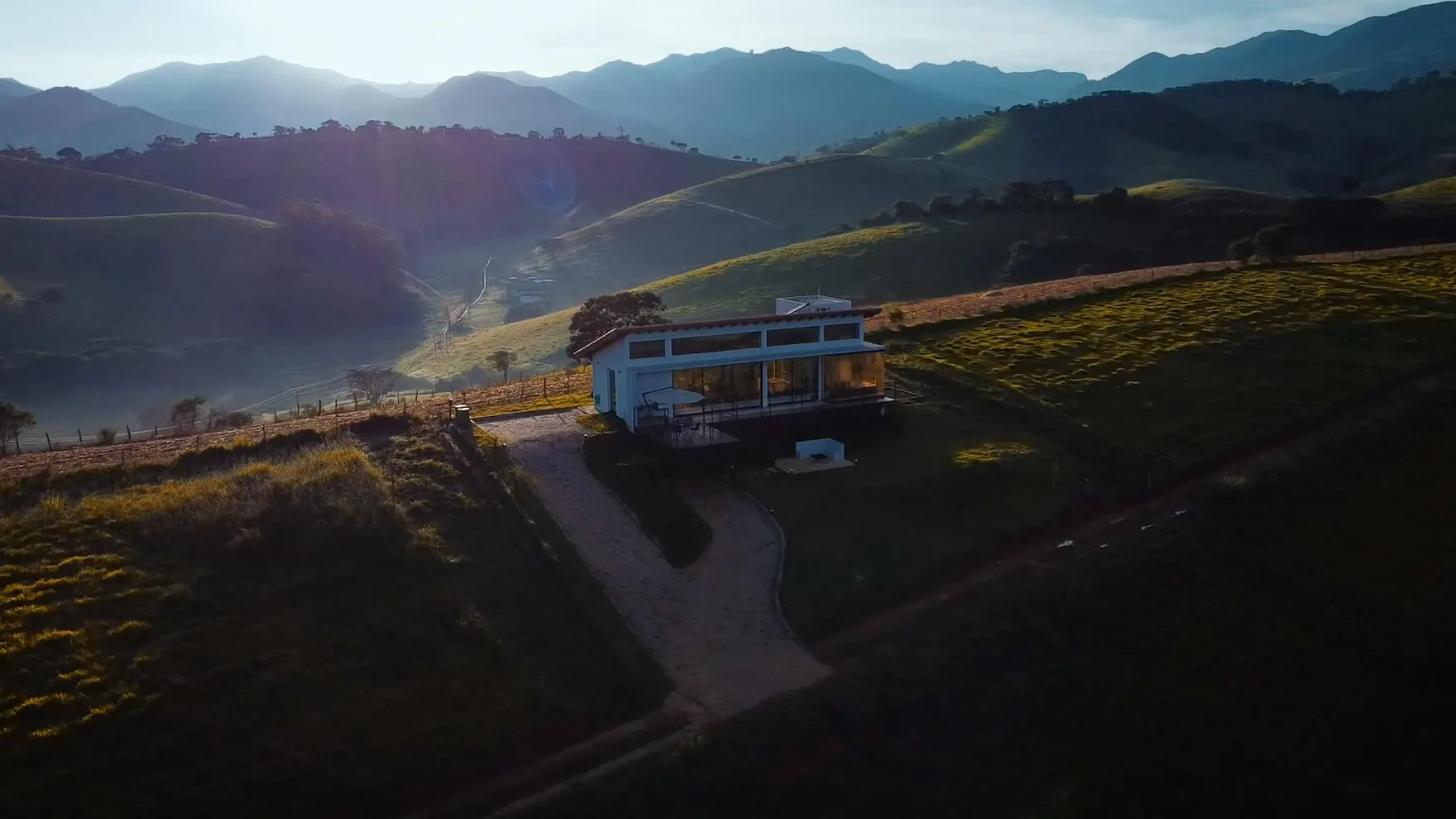 O vale da Serra da Mantiqueira coberto por um mar de neblina ao amanhecer, visto da casa de vidro