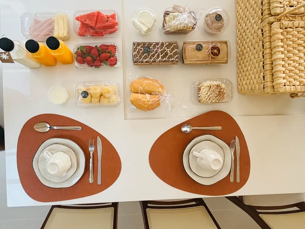 Café da manhã curado servido na casa: pães, frutas, ovos e café fresco
